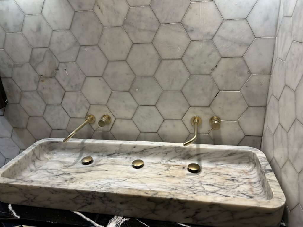 Hexaclean Solutions restaurant fit out cleaning Dublin — luxury marble bathroom with brass fittings cleaned to handover standard