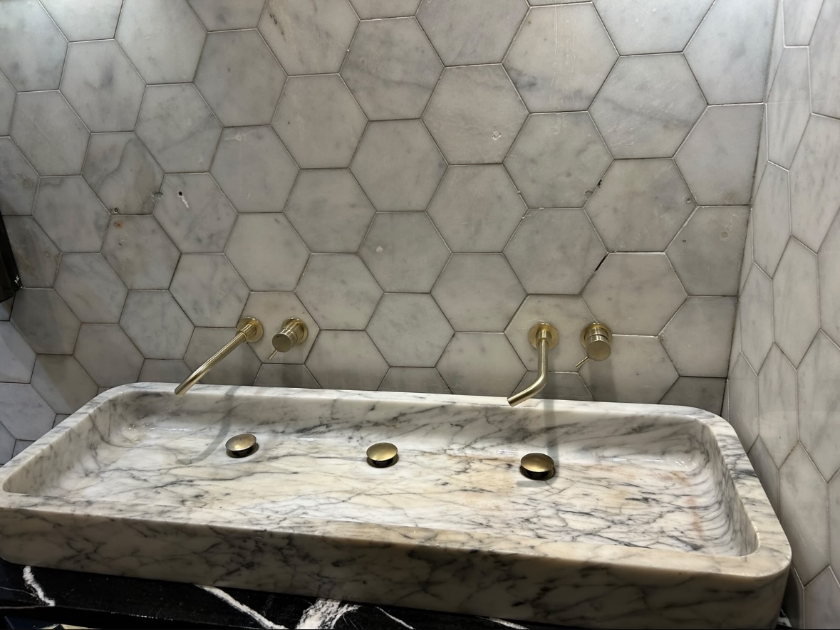 Hexaclean Solutions restaurant fit out cleaning Dublin — luxury marble bathroom with brass fittings cleaned to handover standard