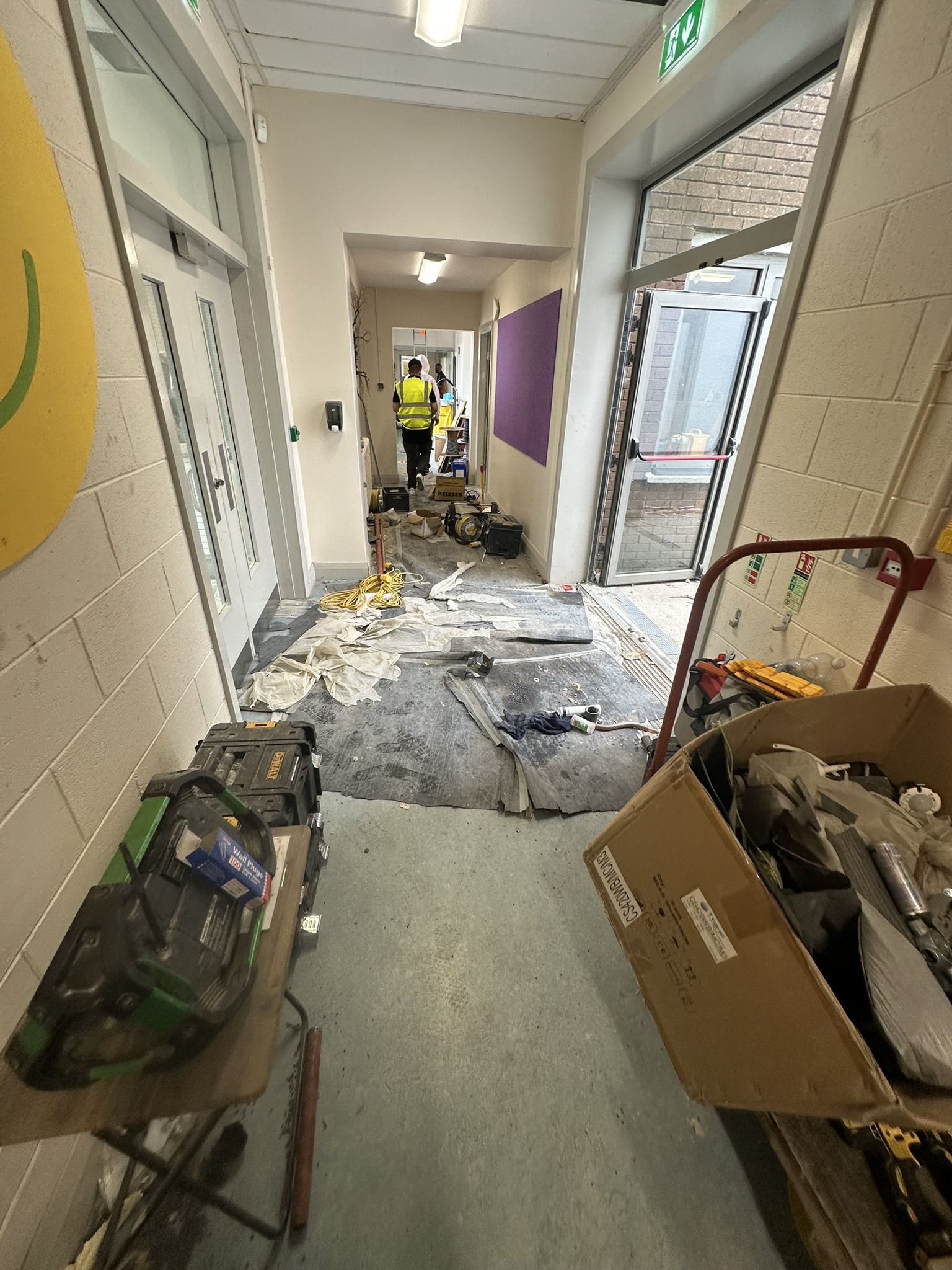 School corridor cluttered with construction materials before cleaning