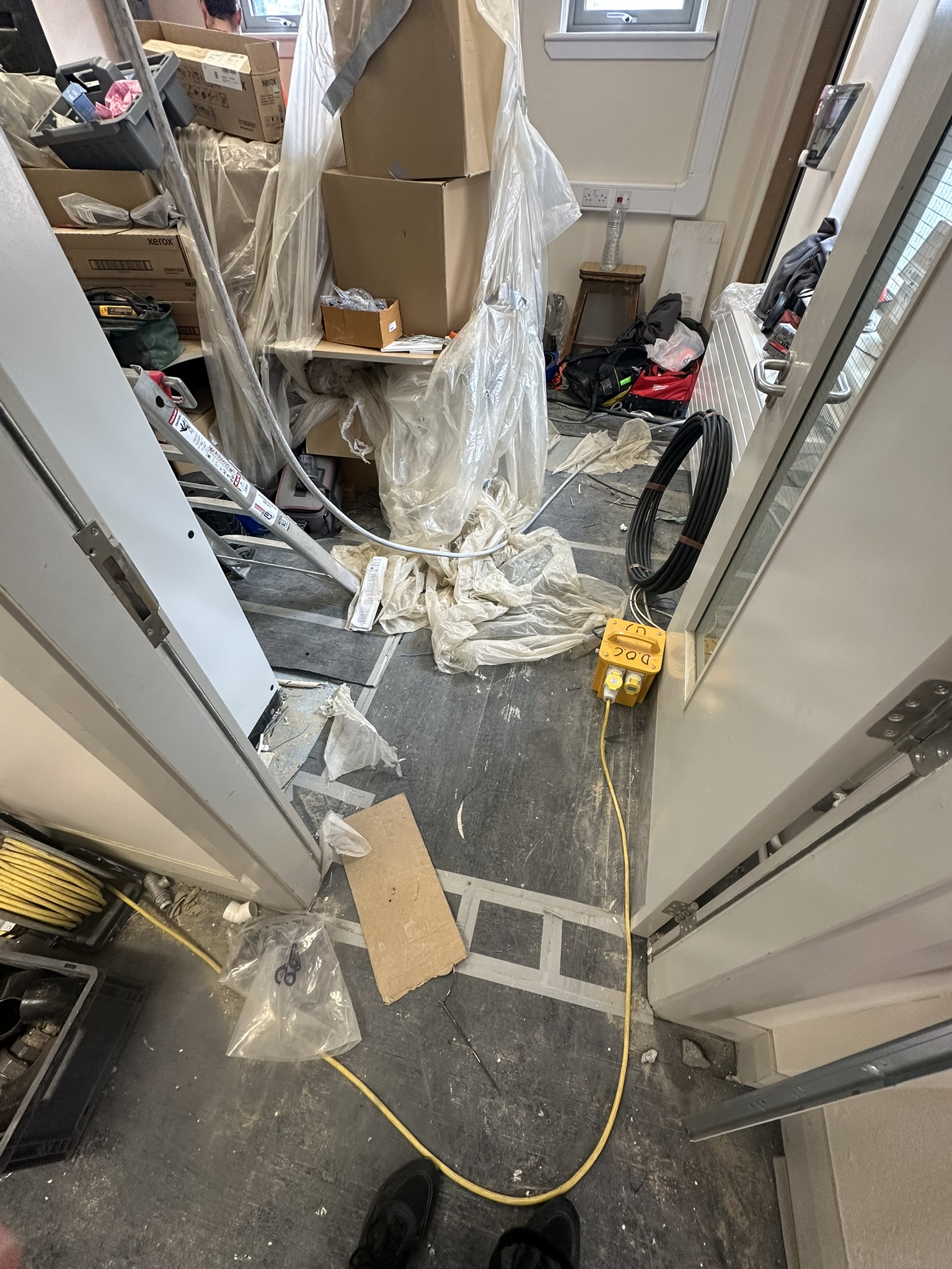 School corridor full of building materials awaiting post construction clean