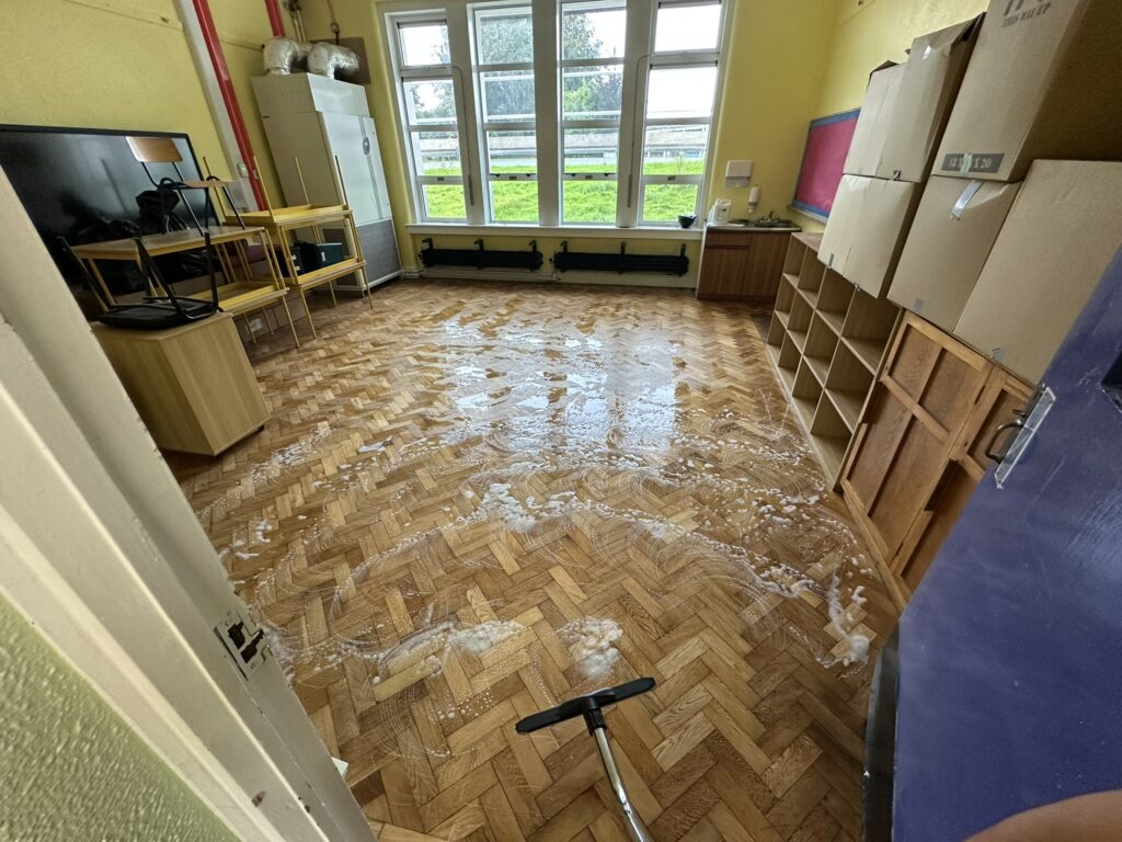 Wet and dry vacuuming wooden floor after buffing in post construction clean