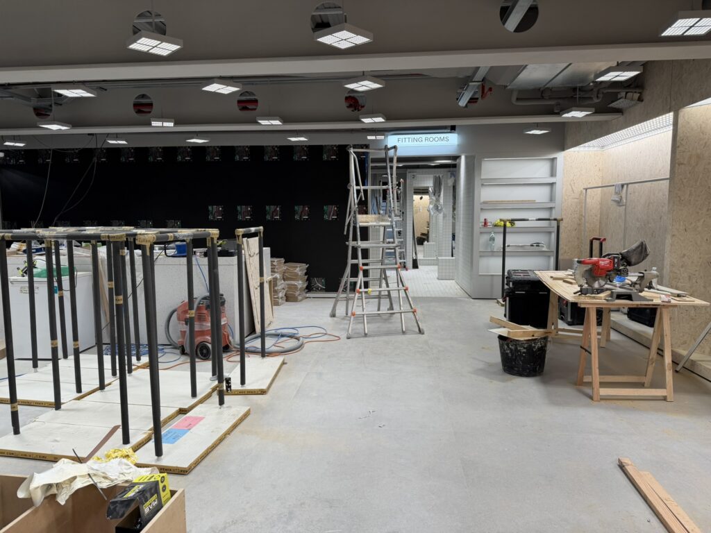 Retail fit-out in Dundrum, Dublin during builders cleaning, showing fitting rooms, unfinished flooring and ongoing construction works before handover.