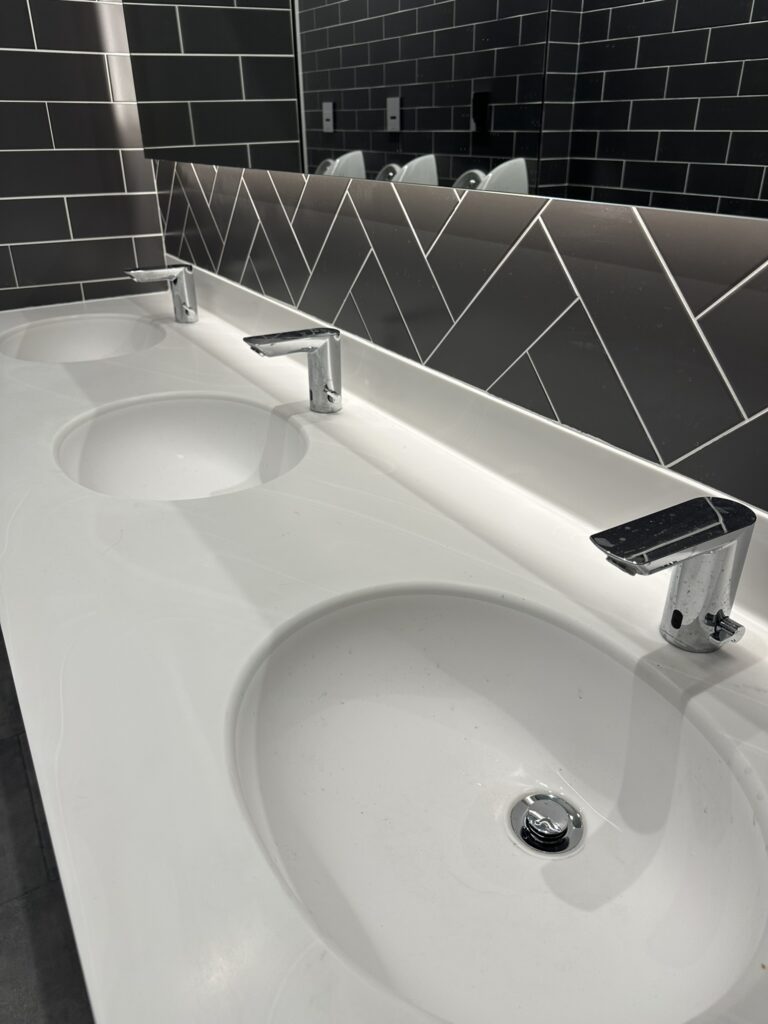 Office fit out cleaning in Sandyford showing cleaned washroom sinks, taps, mirrors and tiled surfaces ready for handover.