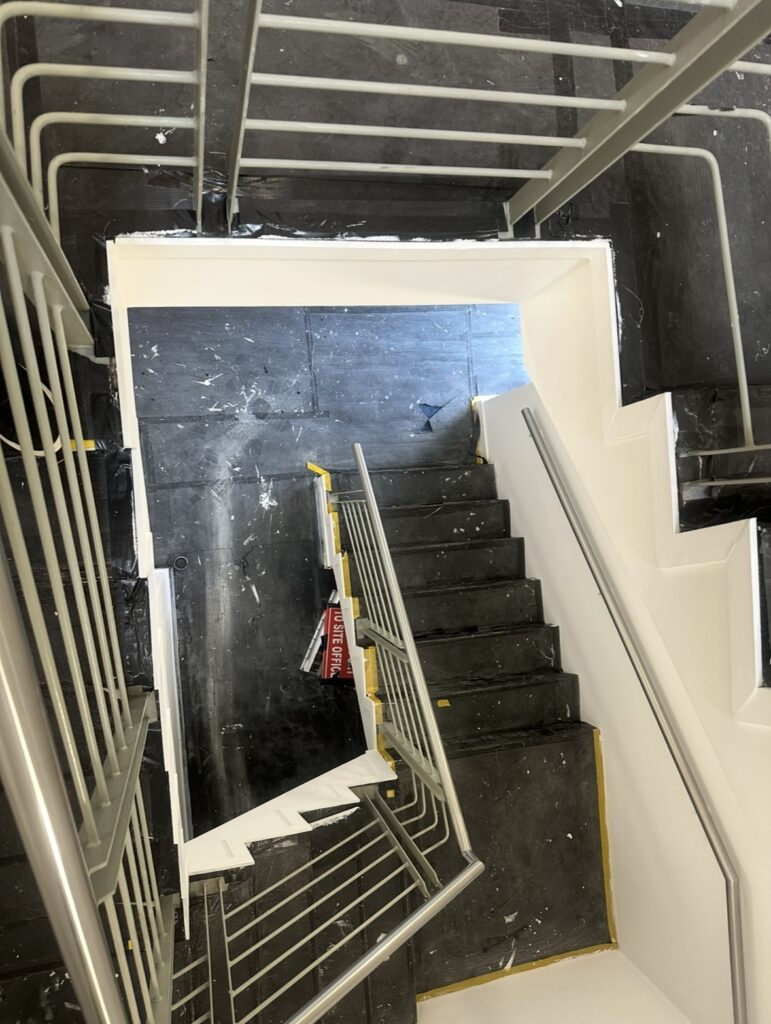 Office fit out staircase before after builders cleaning showing construction dust, paint marks and protective floor covering in Dublin.