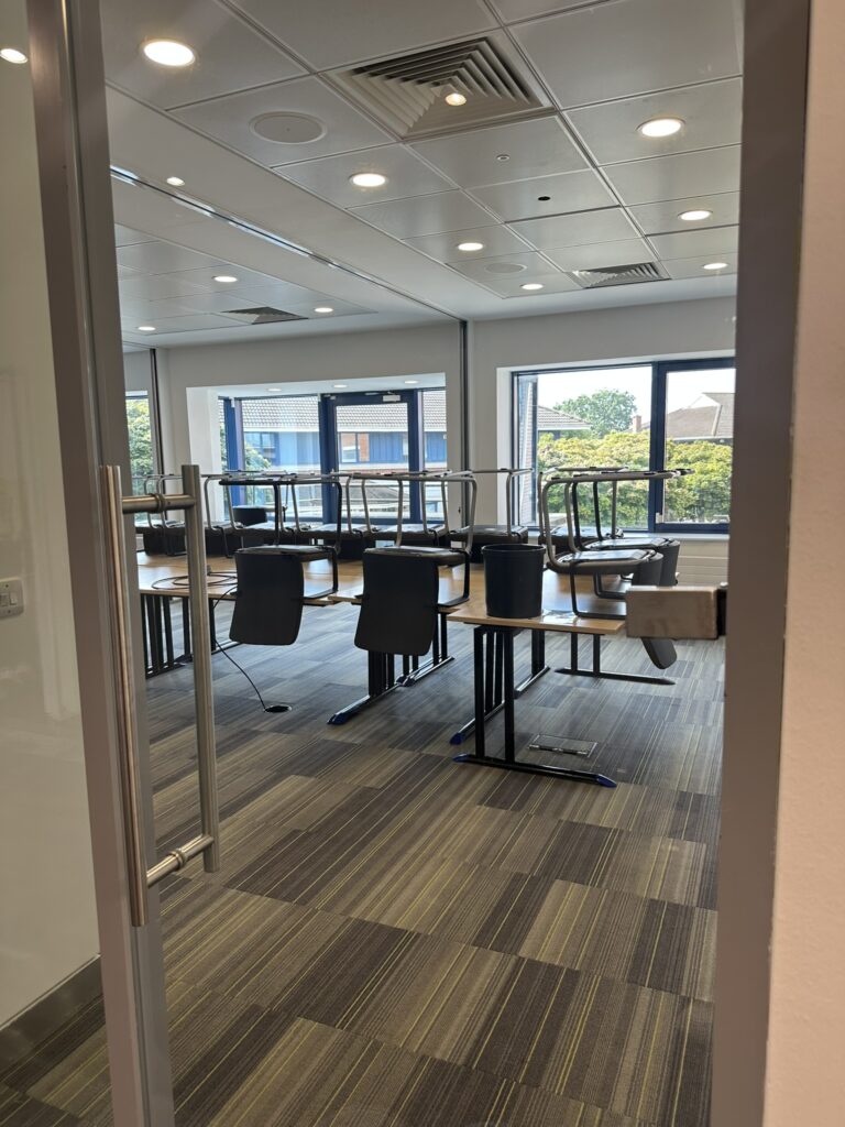 Office prepared for after builders fit out cleaning in Dublin with chairs raised for detailed carpet cleaning.
