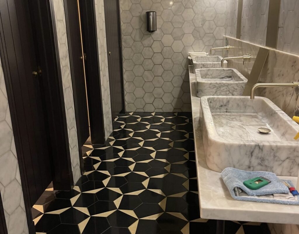 Hexaclean Solutions restaurant fit out cleaning Dublin — luxury bathroom with marble sinks and geometric floor tiles cleaned to handover standard